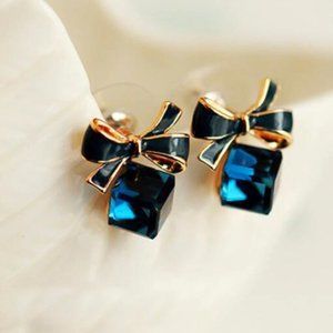 Blue ice cube earrings attached to a black enamel bow